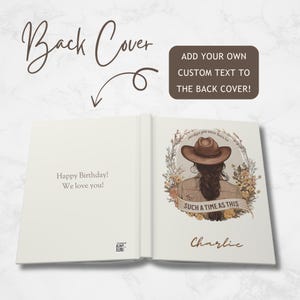 May include: Open book with a cream-colored cover and pages. The left page reads "Happy Birthday! We love you!" The right page features an illustration of a person wearing a hat, with the text "SUCH A TIME AS THIS" and the name "Charlie".