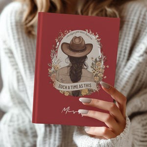 May include: A red journal with the text "Perhaps you were born for such a time as this" and an illustration of a person wearing a cowboy hat. The journal has a floral design and the name "Miss" is written on the bottom.