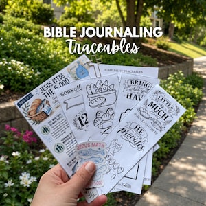 May include: A collection of white paper Bible journaling traceables featuring black ink illustrations of fish and loaves, with text including Jesus Feeds the 5,000, Little is Much When God is in It, and He Provides, held together by a cross-shaped metal clip.