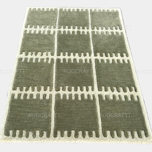 May include: A rectangular area rug with a repeating pattern of olive green squares and off-white borders. The rug has a textured appearance and the text "RUGCRAFT" is visible in several places.