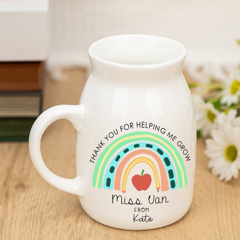 May include: White ceramic mug with a rainbow design and the text "Thank you for helping me grow" and "Miss Van from Kate".