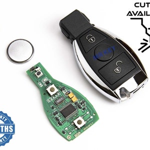 May include: A black car key with two buttons, one for locking and one for unlocking. The key has a silver trim and a small circuit board is visible. The key is on a white surface with a battery and a warranty sticker.