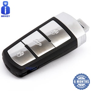 以下が含まれることがあります： 3つのボタンが付いた黒と銀の車のキー。ボタンは銀色の仕上げで、ロック、アンロック、トランクの開閉のアイコンがラベル付けされています。キーはエッジ周りに銀色のトリムがあり、黒いプラスチックボディです。キーは6か月保証です。