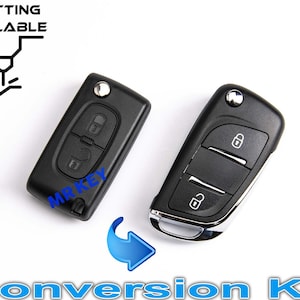 Peut inclure: Deux porte-clés de voiture noirs avec des boutons argentés. Le porte-clés de gauche a deux boutons et le porte-clés de droite en a trois. Les porte-clés sont sur un fond blanc. Kit de conversion.