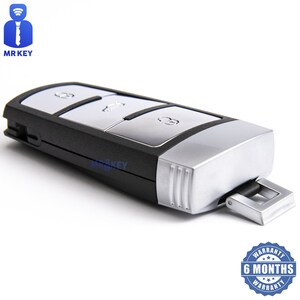 以下が含まれることがあります： 3つのボタンが付いた黒と銀の車のキー。ボタンには、ロック解除、ロック、トランクの開閉のアイコンがあります。キーには、キーホルダーに取り付けるための銀色のループが付いています。キーは6か月間の保証が付いています。