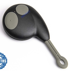 Op de afbeelding: Zwarte afstandsbediening voor de auto met twee grijze knoppen en een grijze sleutelringlus. De tekst "MR KEY" en een "6 MAANDEN GARANTIE" badge zijn aanwezig.