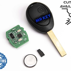 Peut inclure: Une clé de voiture noire avec une lame de clé argentée et un circuit imprimé. La clé a un bouton avec le texte "MR KEY" dessus. Le circuit imprimé est vert et porte le texte "SW". La clé est sur un fond blanc. L'image comprend également une pile, une petite pièce noire et un autocollant qui dit "WARRANTY 6 MONTHS WARRANTY".