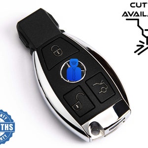 May include: A car key with a black and chrome finish, featuring buttons for locking, unlocking, and other functions. The key has the text "MR KEY" and "CUTTING AVAILABLE" printed on it. A 6-month warranty is also displayed.