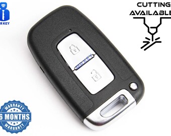 Puede incluir: Llavero de coche negro con dos botones, uno para bloquear y otro para desbloquear. El llavero tiene un borde plateado y una pequeña luz LED. El llavero está sobre un fondo blanco.  "CUTTING AVAILABLE" está escrito en negro sobre fondo blanco.  Una pegatina de garantía con el texto "6 MONTHS WARRANTY" está en la esquina inferior izquierda de la imagen.