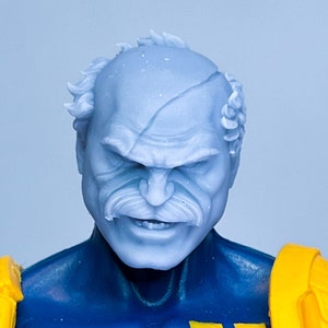 May include: A blue and yellow action figure with a detailed face and a stern expression. The figure is wearing a blue and yellow jumpsuit with a yellow belt and a yellow backpack.