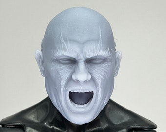 May include: A 3D printed head sculpt of a bald man with a detailed facial expression, including a wide open mouth and visible teeth. The head is painted in a light gray color.