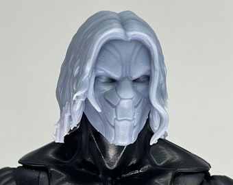 May include: A gray plastic action figure head with long hair and a detailed mask. The mask is gray and has a sharp, angular design.