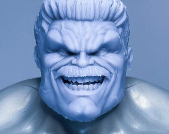 May include: A light blue figurine of the Hulk, a character from Marvel Comics. The figurine shows the Hulk's head and upper torso, with a detailed depiction of his facial features, including a furrowed brow, open mouth, and prominent teeth.