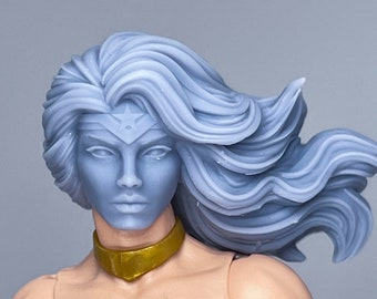 May include: A close-up of a female action figure with long, flowing silver hair. She is wearing a black and gold costume with a star on her forehead.