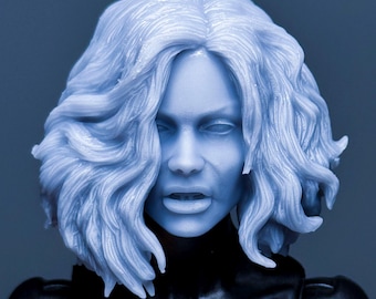 May include: A close-up of a figurine's head and upper body, bathed in a blue hue. The figure has light blue wavy hair and a stern expression. The black and white costume features a bat symbol on the chest.