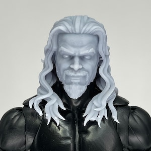 Könnte beinhalten: Nahaufnahme eines grauen, unbemalten Plastik-Actionfigurenkopfes mit langen, fließenden Haaren und einem Bart. Die Figur hat einen ernsten Ausdruck mit zusammengezogenen Augenbrauen und einem leichten Lächeln.