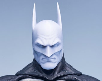 May include: A white plastic action figure of Batman with a black cape and a yellow bat symbol on his chest.