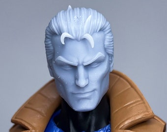 May include: A close-up of a plastic action figure's head and torso. The figure has a white, sculpted head with a serious expression. The figure is wearing a brown jacket, a blue chest piece, and a pink shirt.