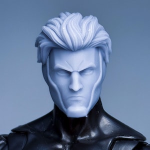 May include: A light blue action figure head with a stern expression and stylized, wavy hair. The figure's face has sharp features and defined lines. The figure is attached to a black torso.