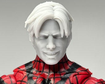 May include: Close-up of a white plastic action figure head with a red and black spider-man suit. The figure has a neutral expression and short, white hair.