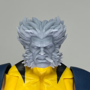 May include: A close-up of a grey plastic action figure head with a white beard and moustache. The figure has a cigarette in its mouth and a serious expression.