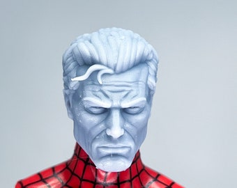 May include: A close-up of a white plastic action figure head with a detailed face and short, styled hair. The head is attached to a red and black Spiderman costume.