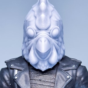 Könnte beinhalten: Eine weiße Plastik-Hühnerkopfmaske mit einem Schnabel und großen Augen. Die Maske wird von einer Person getragen, die eine schwarze Lederjacke trägt.