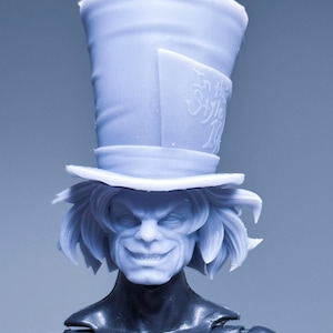 May include: A light blue figurine of a character with a top hat and a sinister grin. The hat has the text "In this Style". The figure has long, wavy hair and a dark-colored torso.