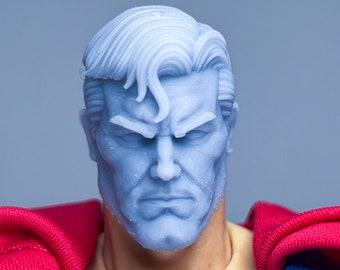 May include: A close-up of a blue and red superhero figure's head and shoulders. The figure has a serious expression and a sculpted, detailed face.