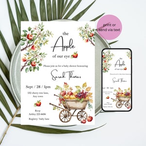 Puede incluir: Una invitaci&oacute;n a una fiesta de bienvenida al beb&eacute; con una ilustraci&oacute;n de acuarela de un carro lleno de manzanas, peras y uvas. El texto dice "the Apple of our eye" y "Sarah Thomas". La invitaci&oacute;n incluye la fecha, la hora y la ubicaci&oacute;n de la fiesta.
