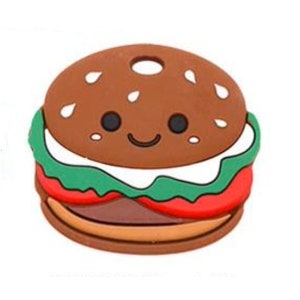 May include: A brown, green, and red silicone toy shaped like a hamburger with a smiling face.