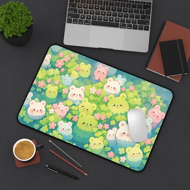 May include: A rectangular mousepad featuring a whimsical design of cartoon bears in various colors, including yellow, pink, and white, set against a backdrop of green foliage and pink flowers. A white mouse and a laptop are also visible.