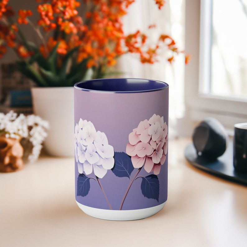 以下が含まれることがあります： 白とピンクの紫陽花の花柄が描かれた紫色のセラミックマグカップ。マグカップは青い縁取りがされています。