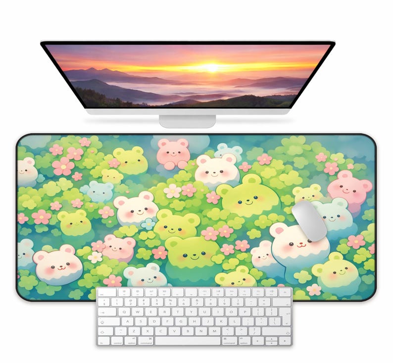 May include: A rectangular mouse pad featuring a colorful illustration of cartoon bears in shades of green, pink, and white, surrounded by flowers. A white computer mouse rests on the pad, with a white keyboard below and a computer monitor above.