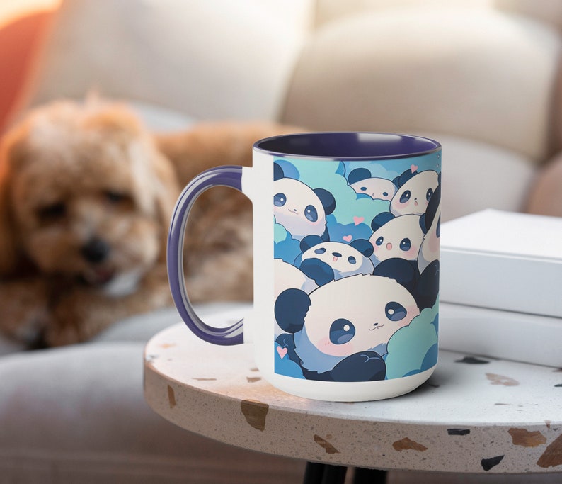 Op de afbeelding: Een witte keramische mok met een paarse rand heeft een ontwerp met meerdere schattige cartoonpanda's met blauwe en witte accenten. De panda's worden omringd door blauwe en witte wolken met roze harten.