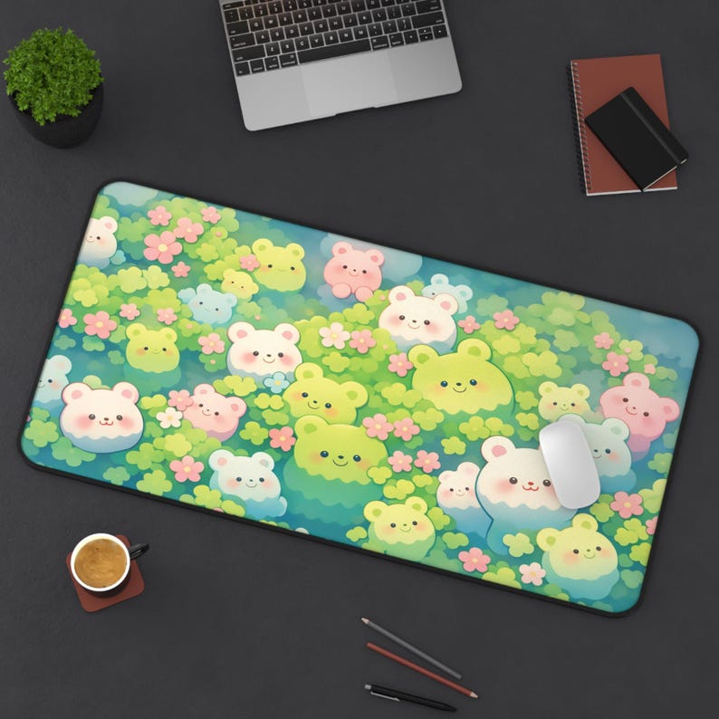 May include: A rectangular mousepad featuring a whimsical design of cartoon bears in shades of green, pink, and white, set against a backdrop of flowers and foliage. The mousepad has a black border and a white mouse is on the right side.