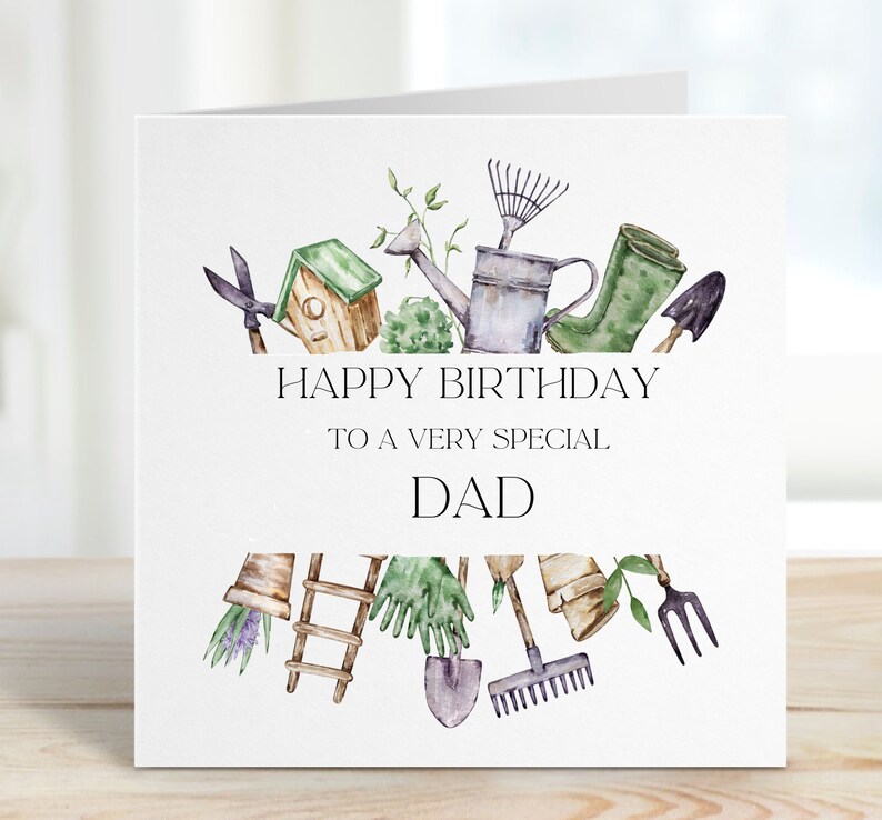 May include: A white card with a watercolor illustration of gardening tools, including a watering can, rake, shears, and a birdhouse. The text "Happy Birthday to a very special Dad" is printed on the card.