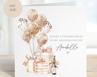 Puede incluir: Una tarjeta de cumpleaños con una ilustración de acuarela de globos, regalos y una botella de champán. La tarjeta dice "Feliz cumpleaños número 27 a mi increíble hermana Annabelle".