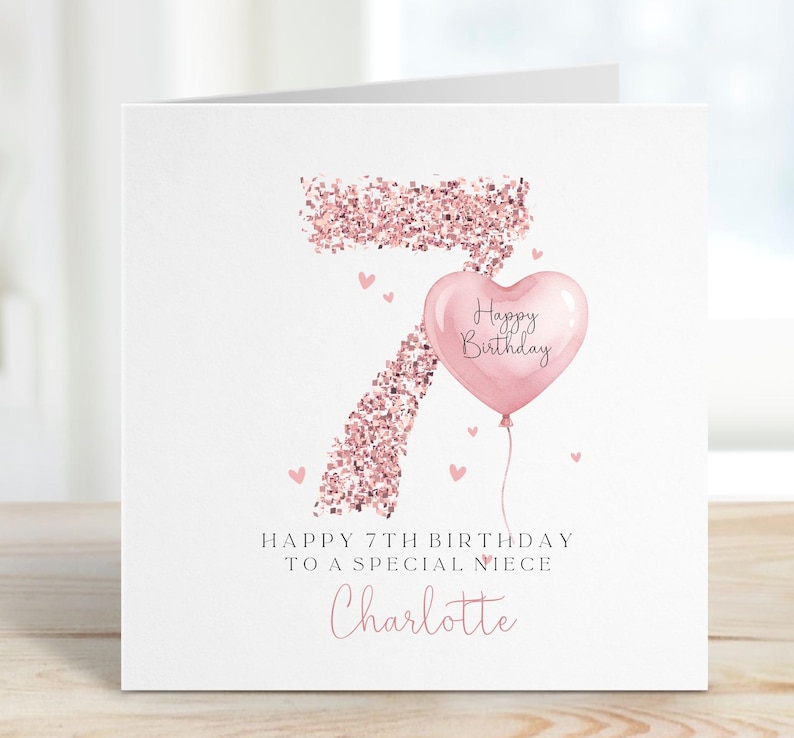 May include: A square birthday greeting card featuring a large number 7 rendered in rose gold glitter texture. A light pink heart-shaped balloon with the text Happy Birthday is attached to the number. Below, the text reads Happy 7th Birthday to a special niece and the name Charlotte in pink script.
