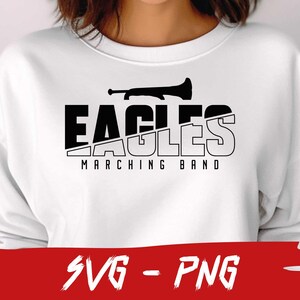 Pu&ograve; includere: Felpa bianca con un design grafico bianco e nero che dice "Eagles Marching Band" con un grafico di tromba.