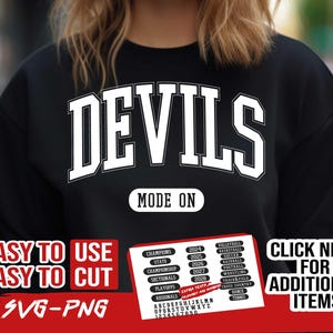 Op de afbeelding: Zwart sweatshirt met witte tekst die "DEVILS" in een college-lettertype leest. De tekst "MODE ON" staat onder het woord "DEVILS". De afbeelding bevat ook een rood-witte afbeelding met de tekst "EASY TO USE EASY TO CUT SVG-PNG" en een lijst met sporten en jaren. De afbeelding bevat ook een lijst met letters en cijfers.