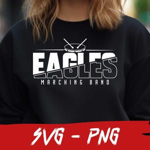 Pu&ograve; includere: Felpa nera con testo bianco che recita "Eagles Marching Band" e un'immagine di un tamburo con le bacchette.