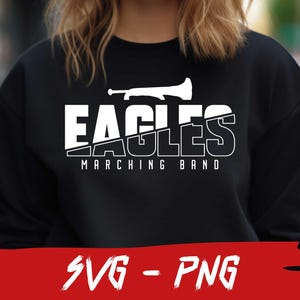 Pu&ograve; includere: Felpa nera con testo bianco che recita "Eagles Marching Band" e una silhouette bianca di una tromba.