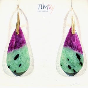 May include: A pair of teardrop-shaped earrings. The top portion is a deep magenta color, transitioning to a speckled green at the bottom. The earrings have gold-colored hooks. The brand name "TUMAY creations" is visible.