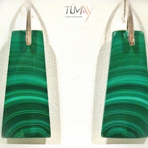 Peut inclure: Une paire de boucles d'oreilles rectangulaires en malachite avec des crochets argentés. Les boucles d'oreilles présentent une couleur verte vibrante avec des motifs en bandes vertes plus foncées. Les boucles d'oreilles sont de Tumay Creations.