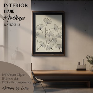 May include: A framed print of a black and white line drawing of ginkgo leaves on a cream background. The frame is brown wood with a black mat. The print is hanging on a light beige wall in a modern interior setting.