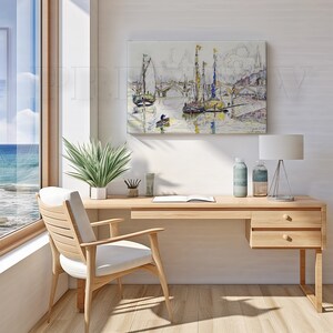 May include: A light wood desk with a white chair, a painting of boats on the water, and a window with a view of the ocean. The desk has a lamp, two bottles, and a plant.