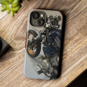 May include: A phone case with a graphic of a vintage motorcycle with a blue and black color scheme. The motorcycle has a large front tire and a detailed engine.