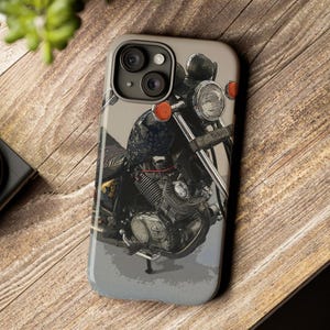 May include: A close-up of a black motorcycle with a chrome headlight and handlebars. The motorcycle is on a gray background.