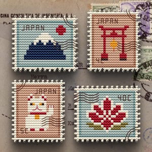 May include: Four square, cross-stitch style stamps with a Japanese theme. Each stamp features a different design: Mount Fuji, a traditional gate, a beckoning cat, and a lotus flower. The word "JAPAN" is printed on three of the stamps.